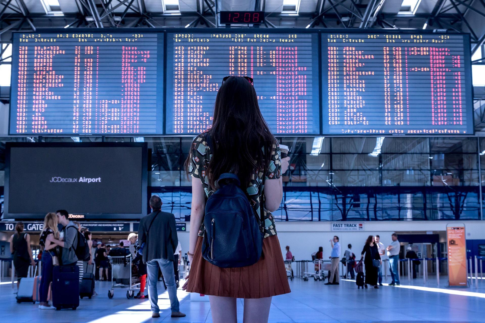 Reisender am Flughafen mit Blick auf startende Flugzeuge