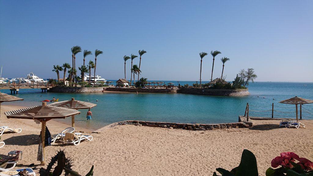 Kleine Insel mit Palmen, Sonnenschirmen und Lagune am Strand des Marriott Beach Resort