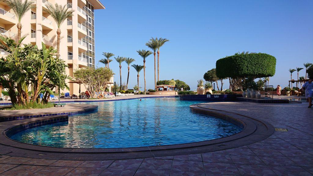 Großer geschwungener Pool im Marriott Beach Resort mit Palmen und Hotelgebäude